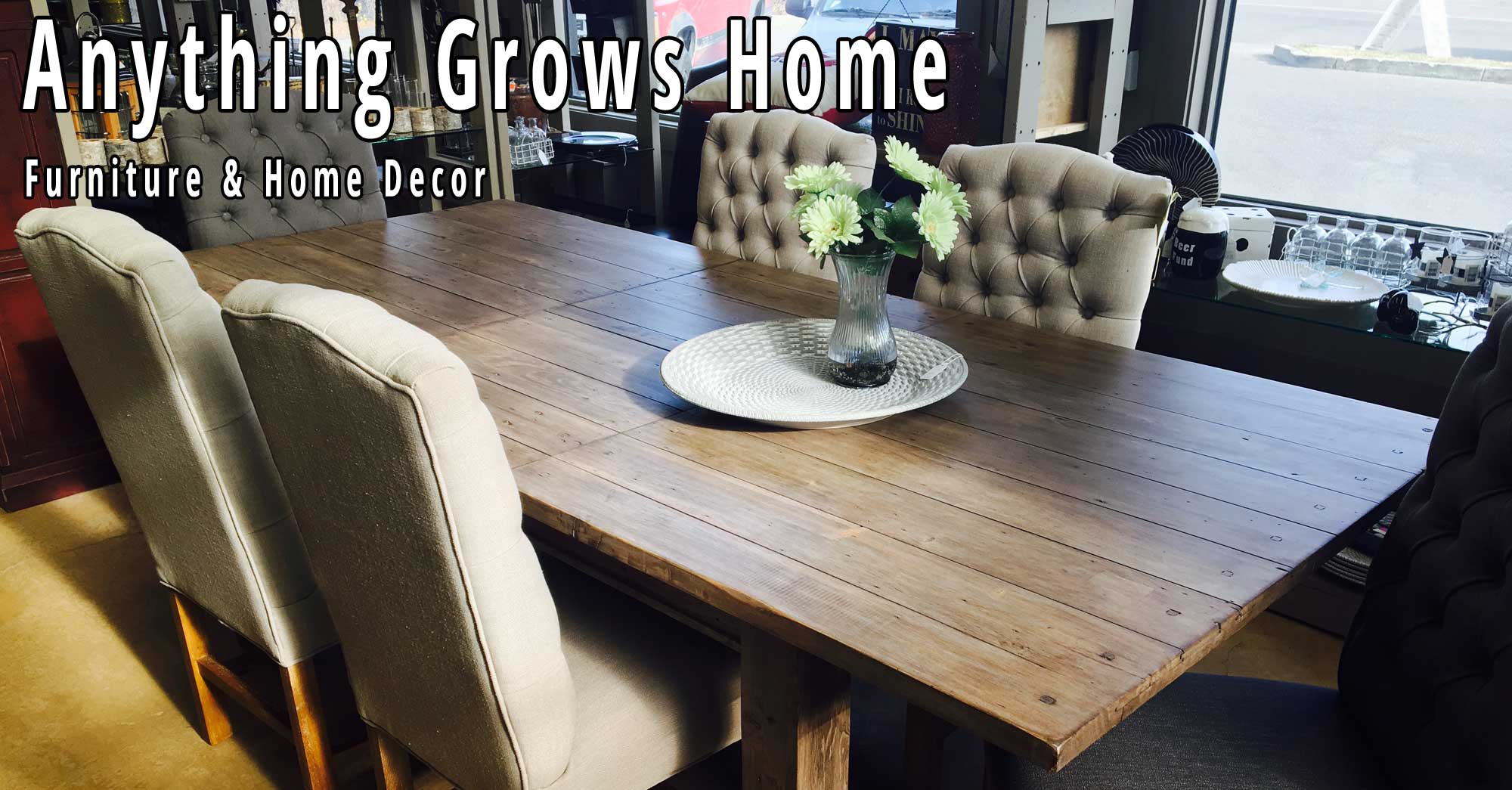 Reclaimed-wood dining table with tufted linen chairs in the Anything Grows Home showroom